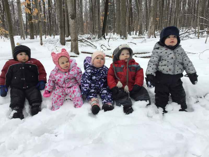 infants sitting in the snow wearing snowsuits